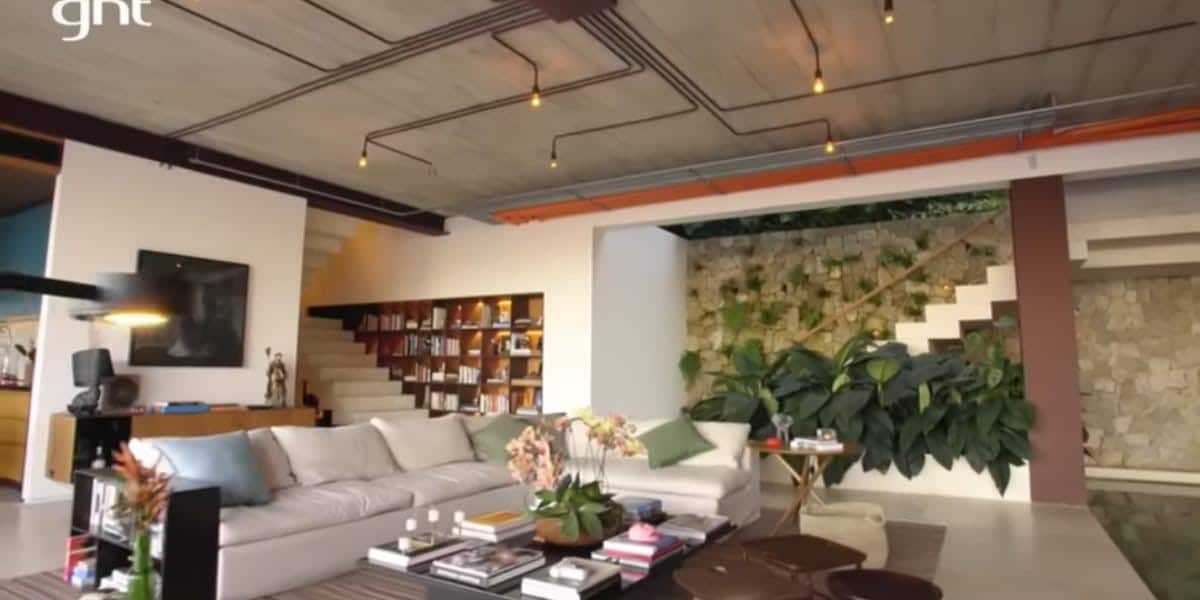 Sala de estar da mansão de Murilo Benício com jardinagem e uma escada (Foto: Reprodução/Youtube)